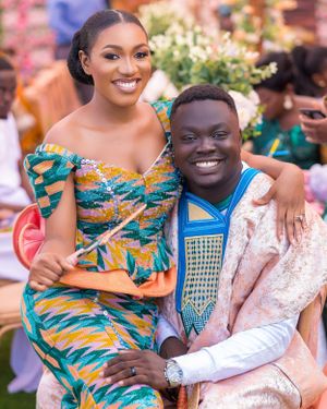 Couple in colorful African print and traditional attire share joyful moments together.