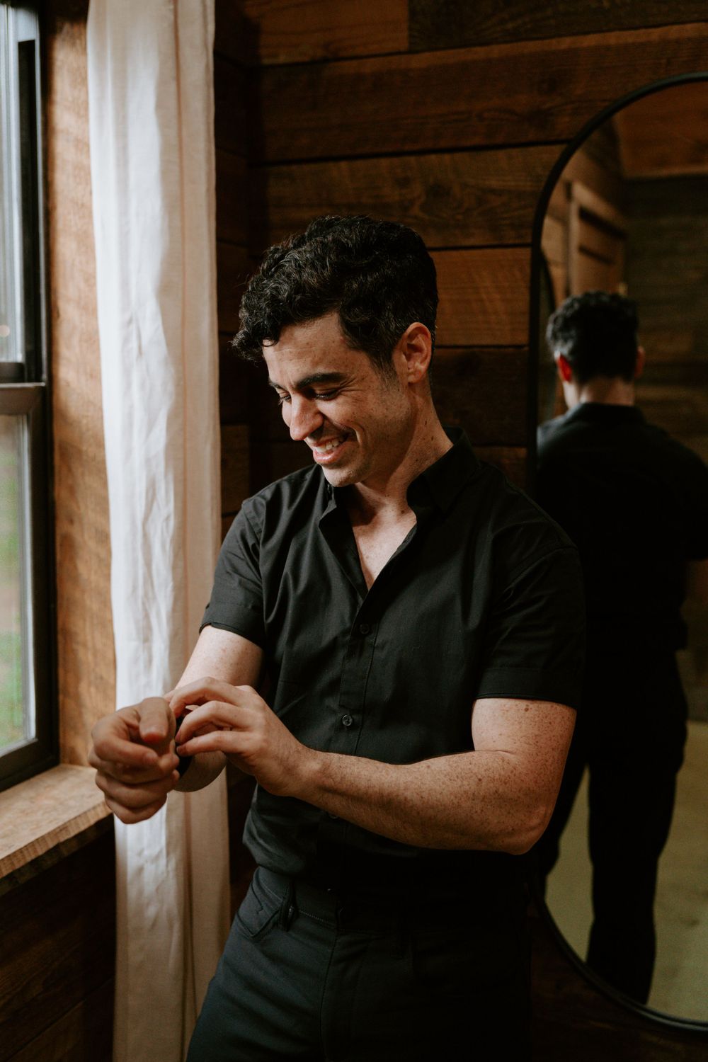 A candid moment by a rustic cabin window with warm natural lighting.