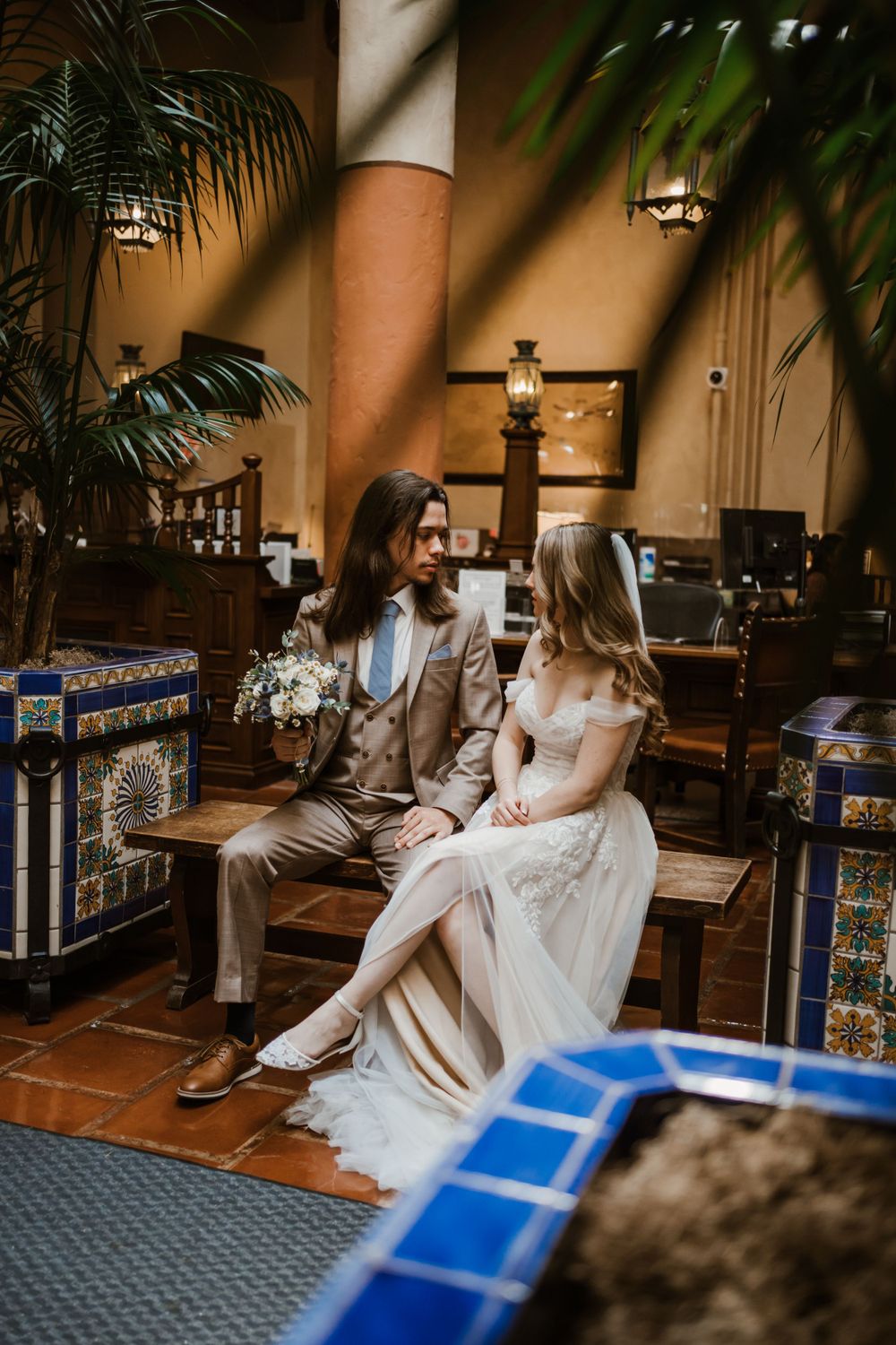 A casual wedding moment captured in a tropical-themed space with decorative tiles.