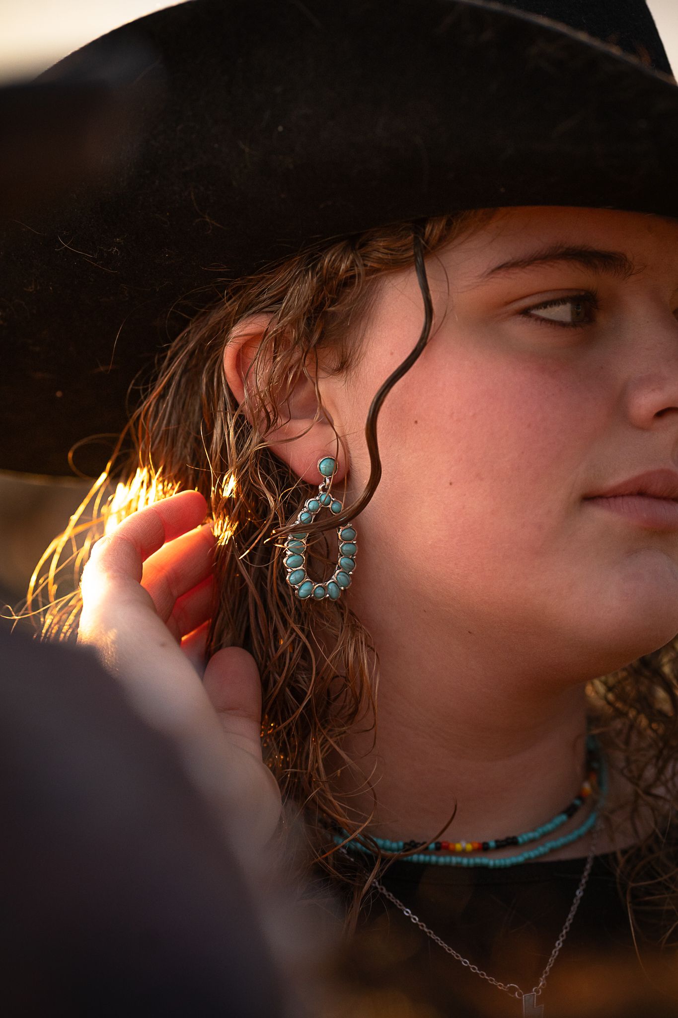 Turquoise jewelry and western accessories sparkle in warm sunset lighting.