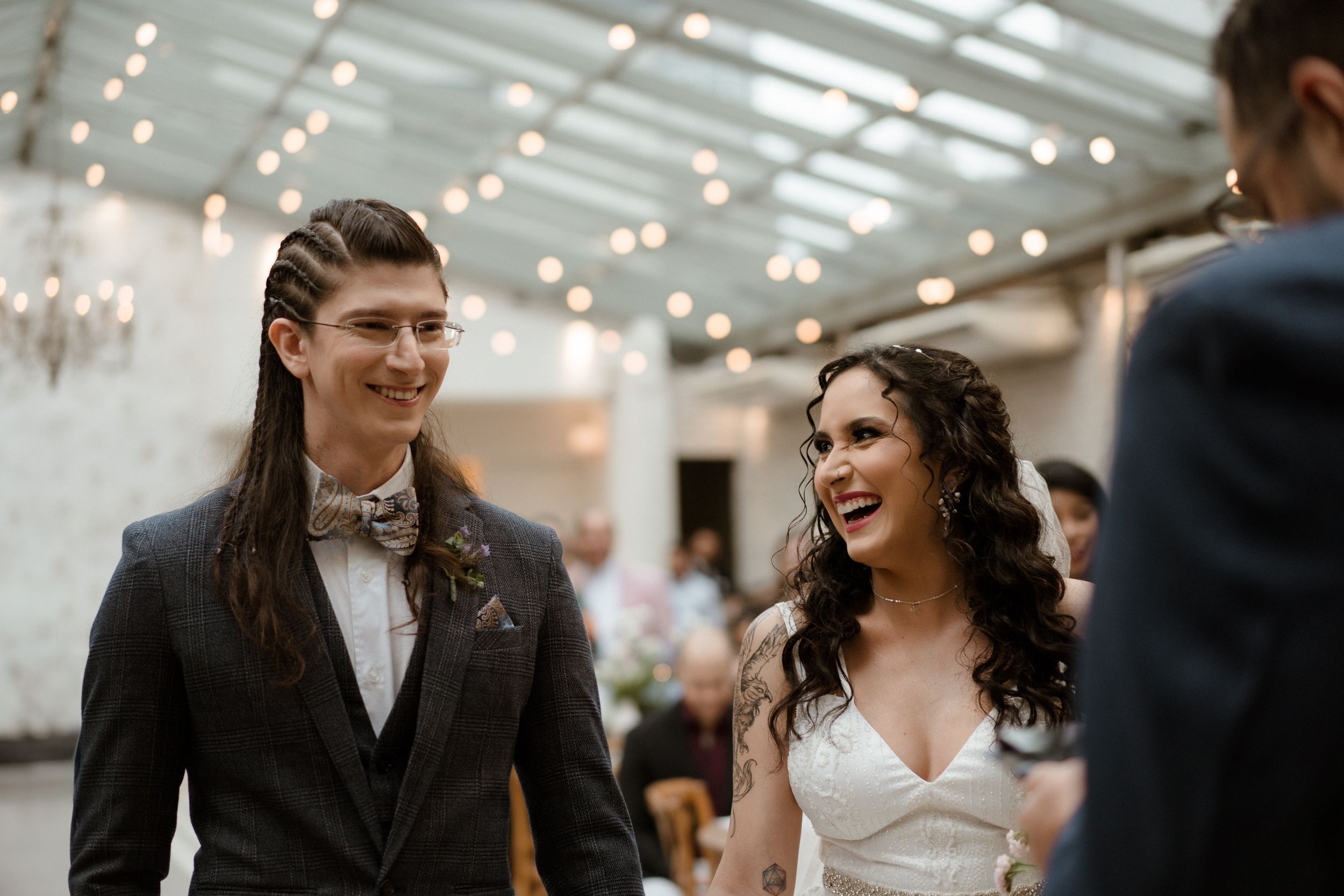 Wedding ceremony in an elegant indoor venue with crystal chandeliers.