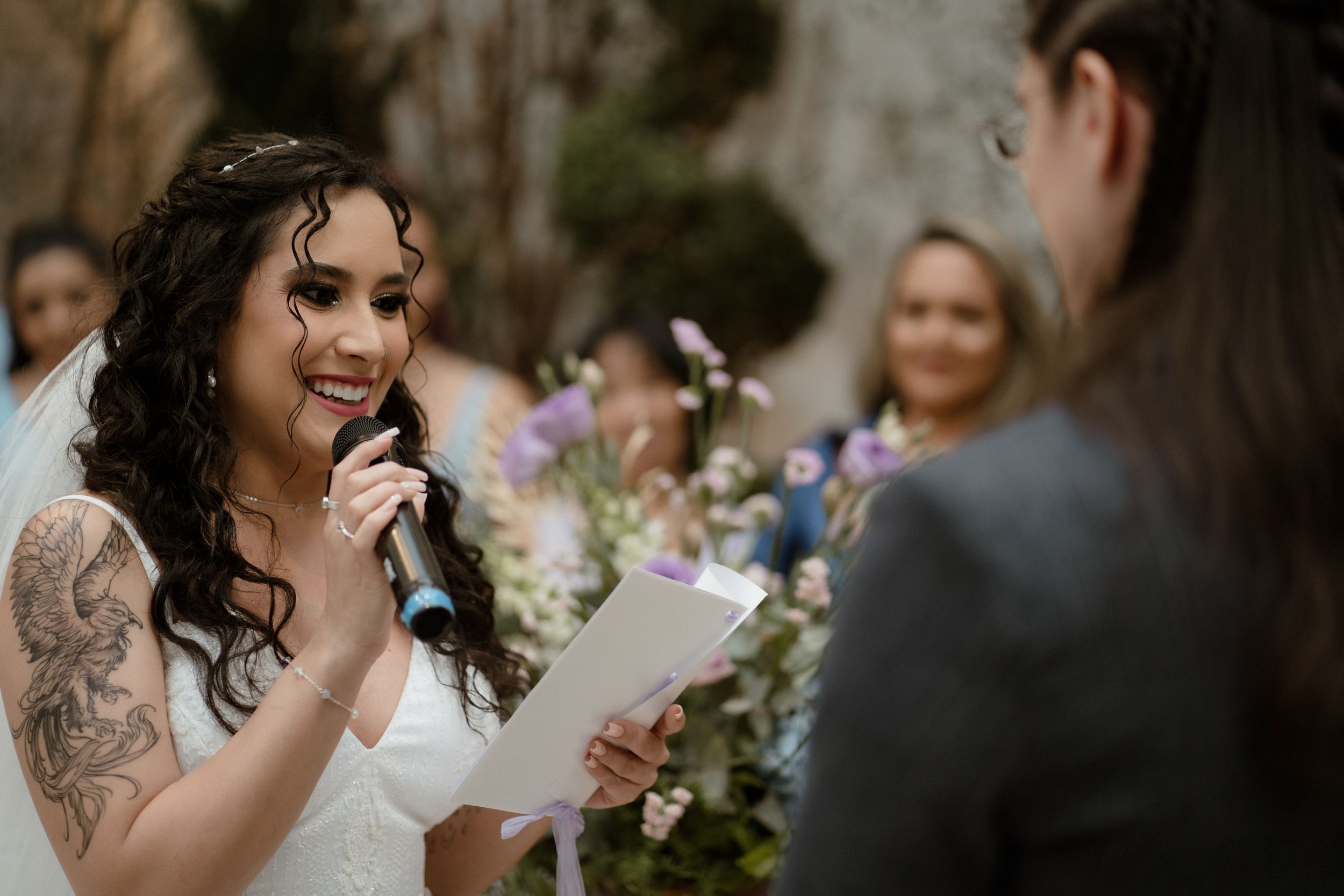 Intimate wedding ceremony moment with blurred background and floral decor.