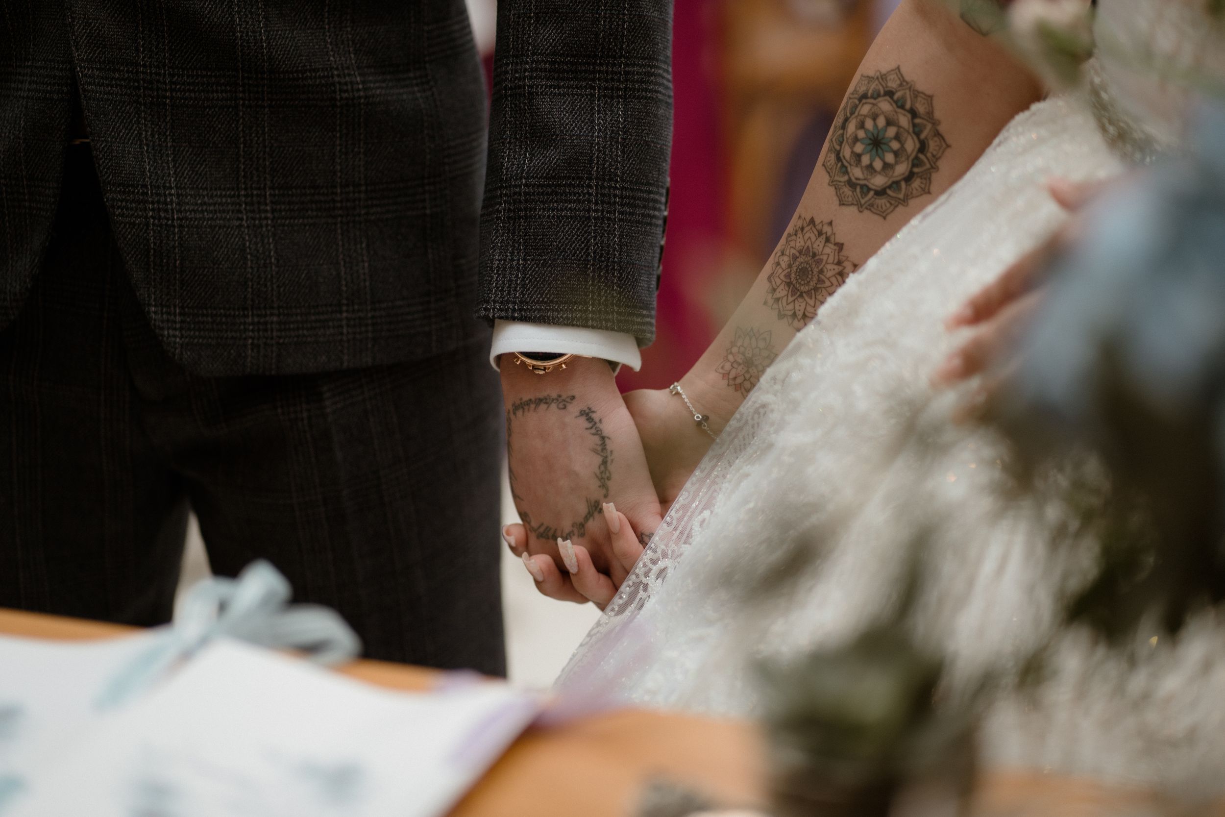 Close-up view of hands showing intricate henna tattoo designs during a wedding ceremony.