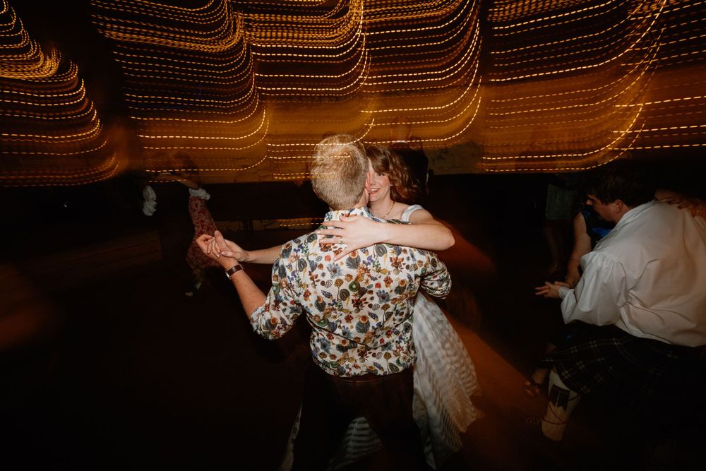 Dance floor moment captured with romantic lighting and motion effects at evening reception.