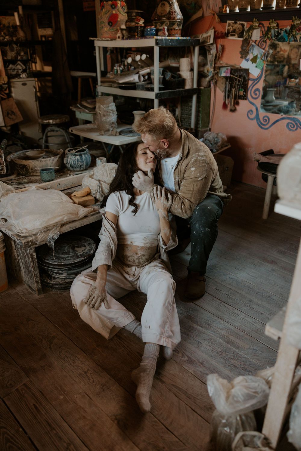 Couple embraces in vintage rustic shop interior with wooden floors and antique decor creating cozy atmosphere.