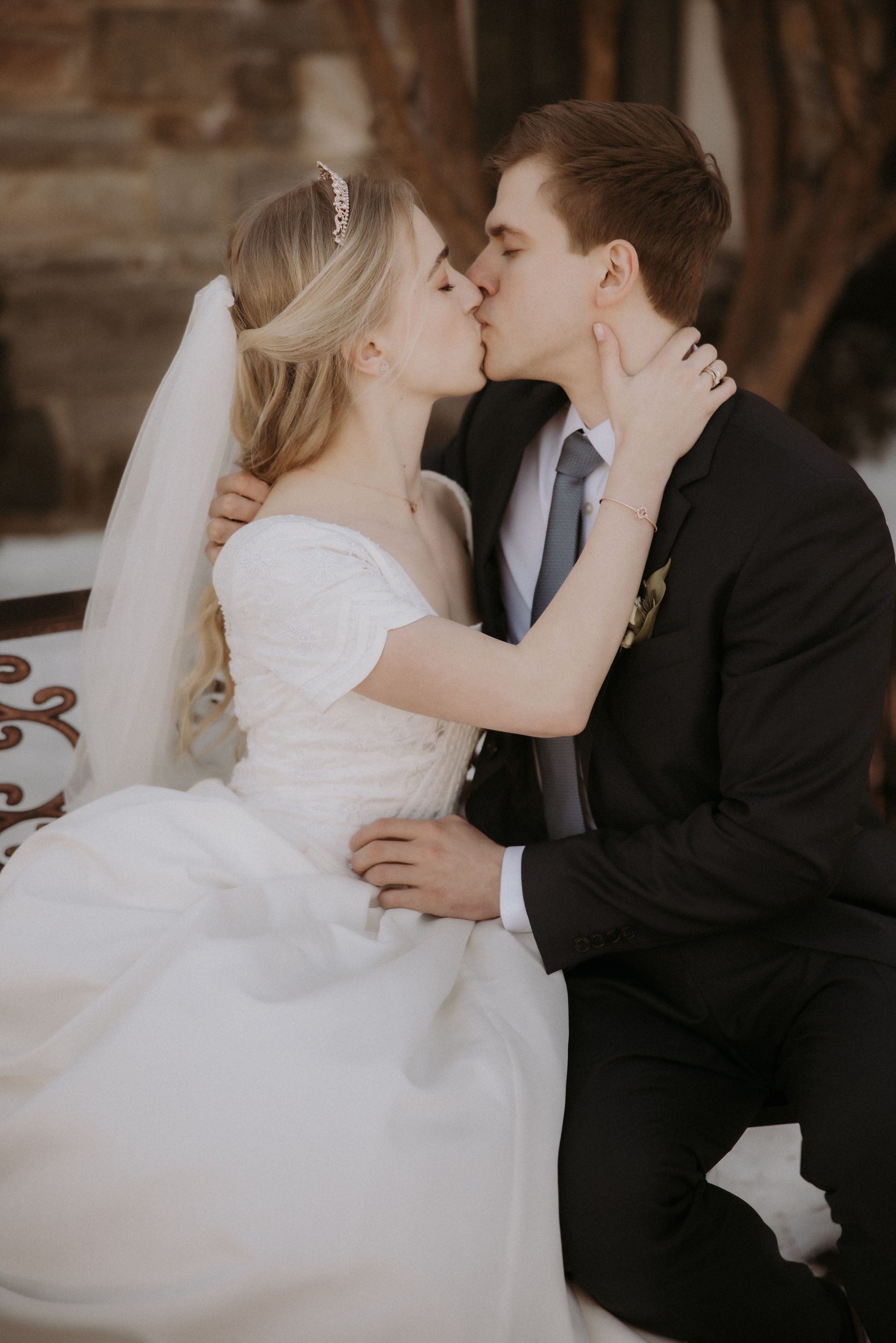 A romantic wedding sequence showing a couple sharing their first kiss in traditional white dress and black suit.