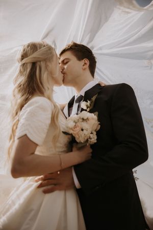 Intimate wedding portraits showing tender moments between newlyweds with soft lighting and white florals.