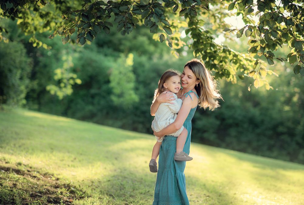 a mother and daughter are laughing while playing during the lifestyle photo session at the Lake Ontario in Oakville