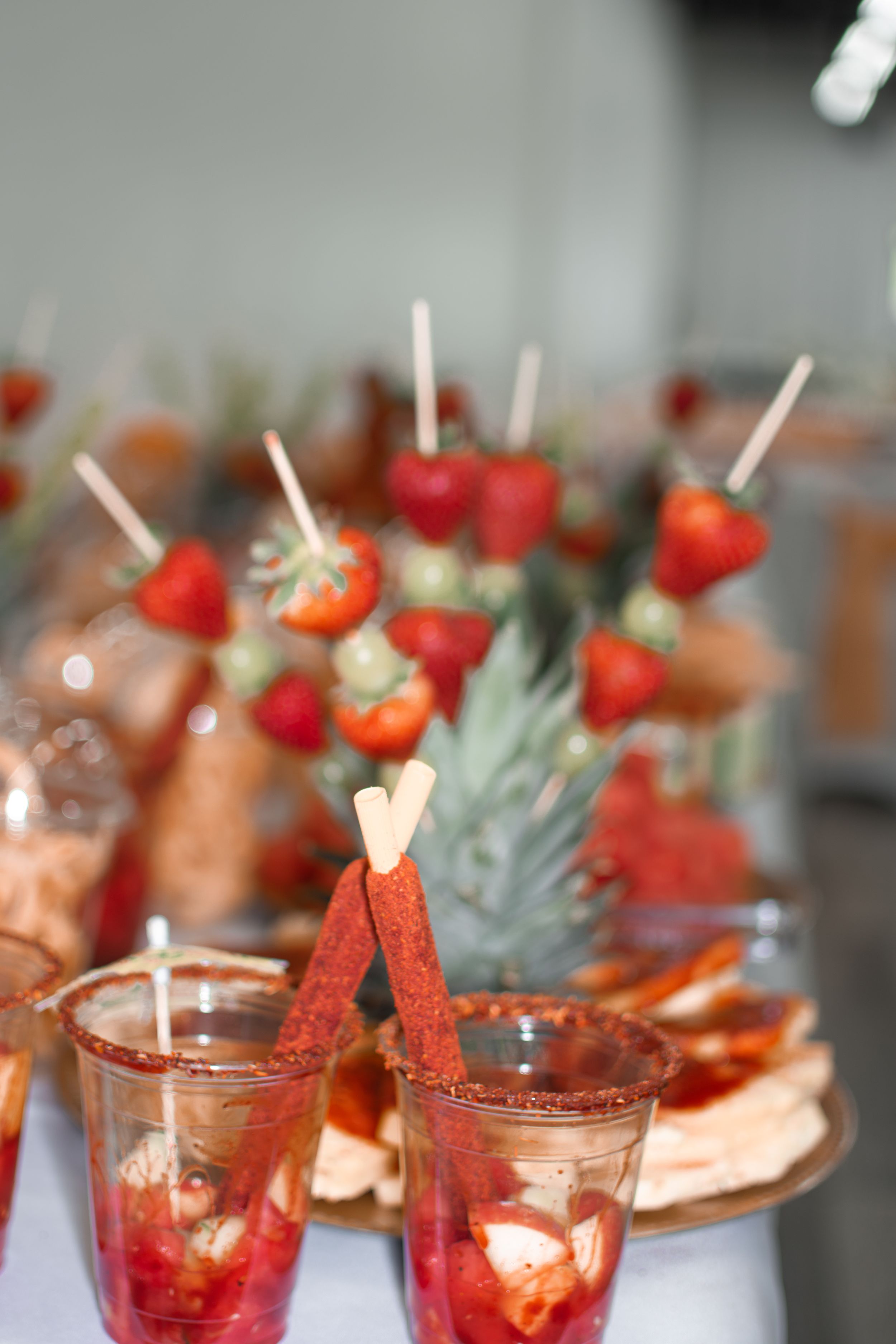 Elegant party appetizers with fresh strawberries and cocktails arranged on a serving table.