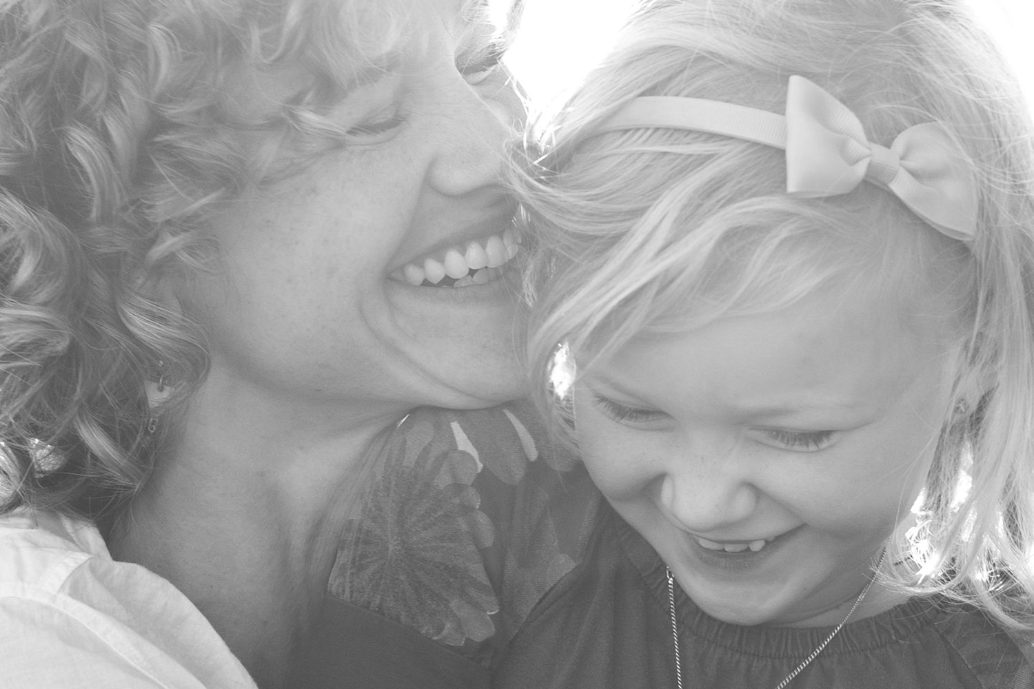 Black and white candid photo capturing shared laughter and joy between two people.