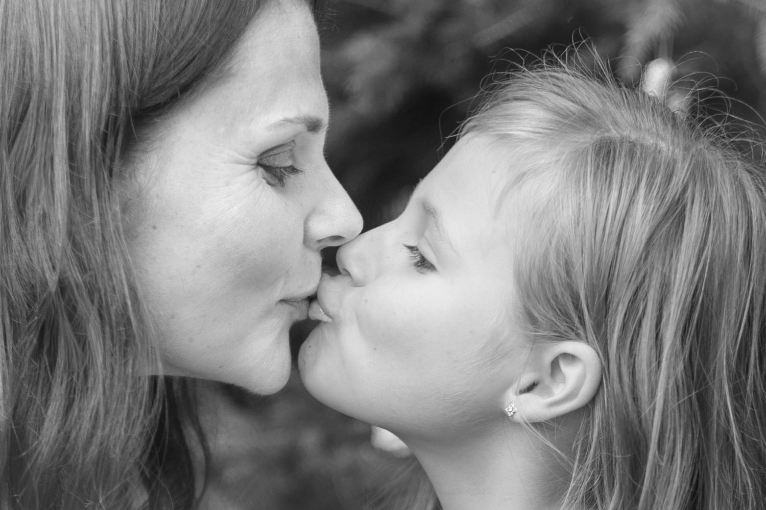 Intimate black and white portrait capturing a tender moment between parent and child.