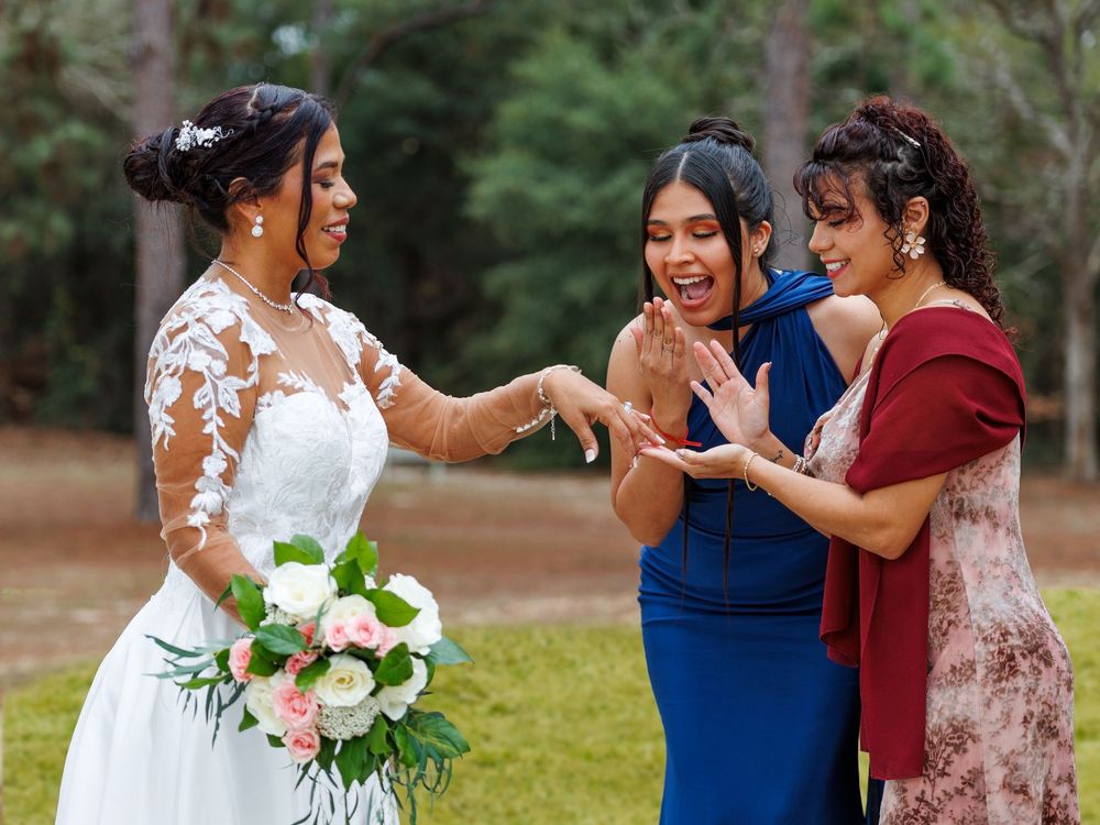 Wedding party celebrates outdoors with bridal couple and guests in formal attire.