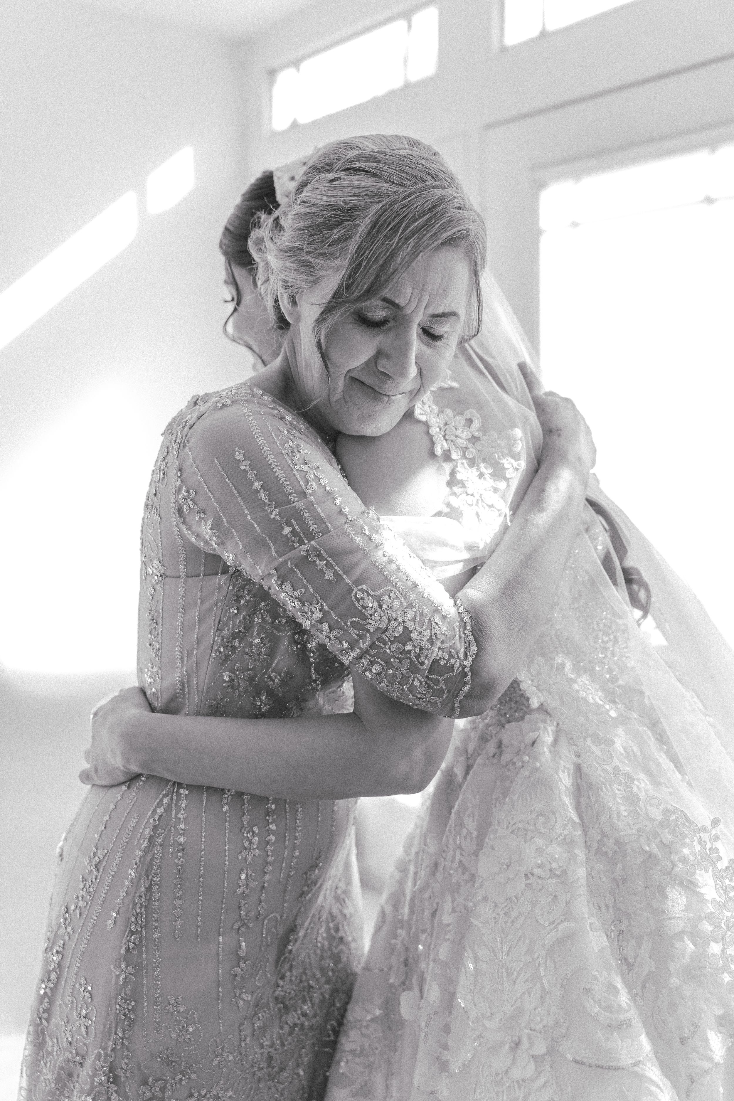 Ethereal bridal preparation moment with soft white lighting and delicate lace details.