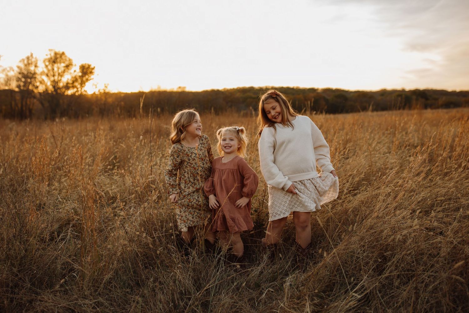 A family sits together in a golden wheat field at sunset creating a warm and intimate outdoor portrait.