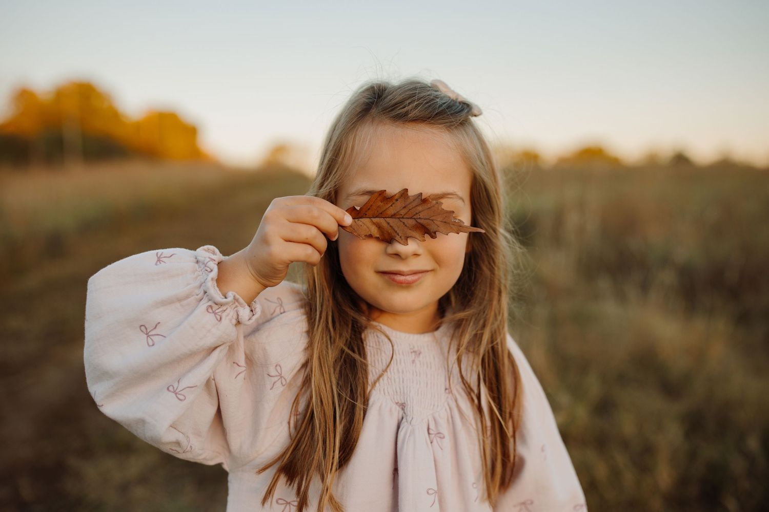 A series of candid outdoor photos at sunset showing someone in a white blouse against an autumn field backdrop.