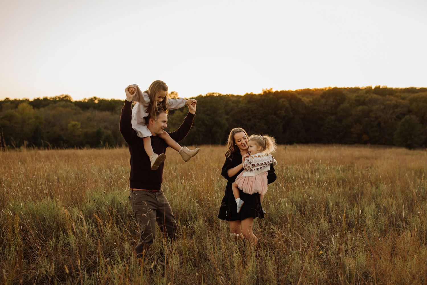A couple embraces lovingly in a golden autumn field during sunset, creating a romantic silhouette against the warm sky.