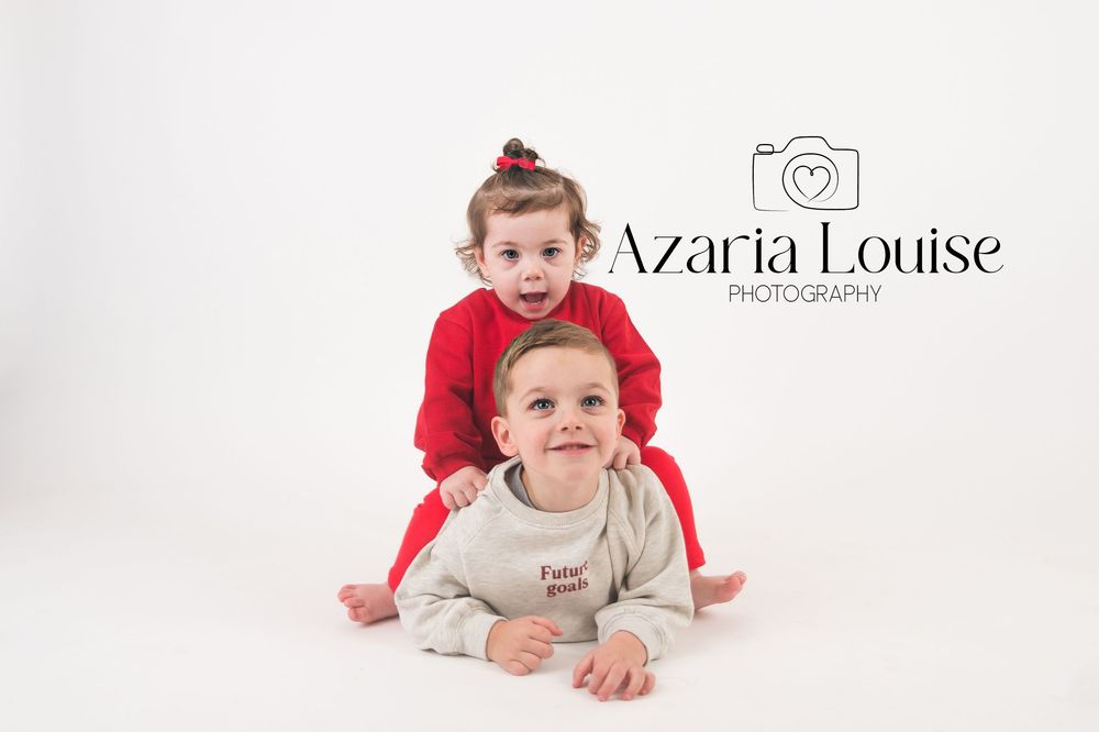 Sweet portrait of siblings in coordinated holiday outfits on white background with photography studio logo.