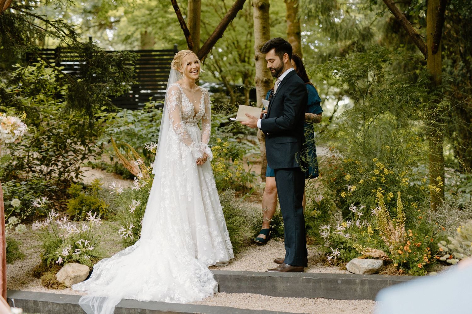 Wedding couple sharing intimate moment on garden path surrounded by greenery.