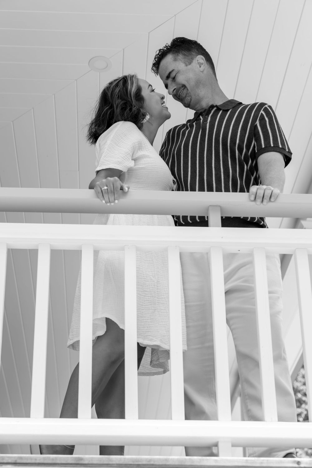 Black and white series of romantic moments on a white porch railing.