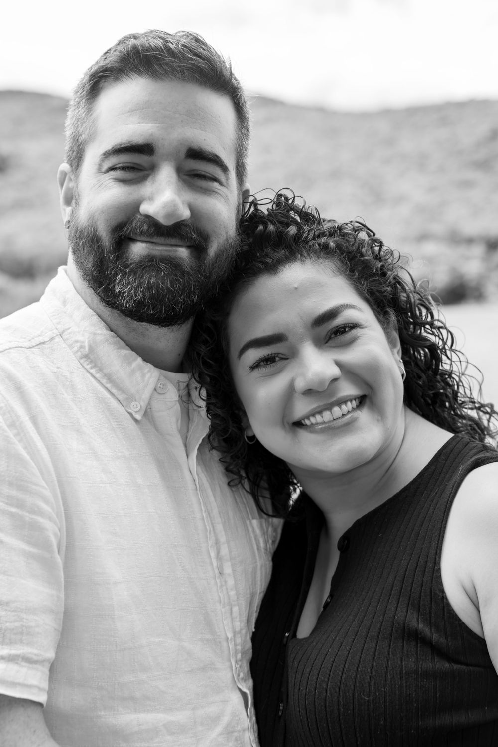 Black and white close-up portraits of a couple smiling and embracing.