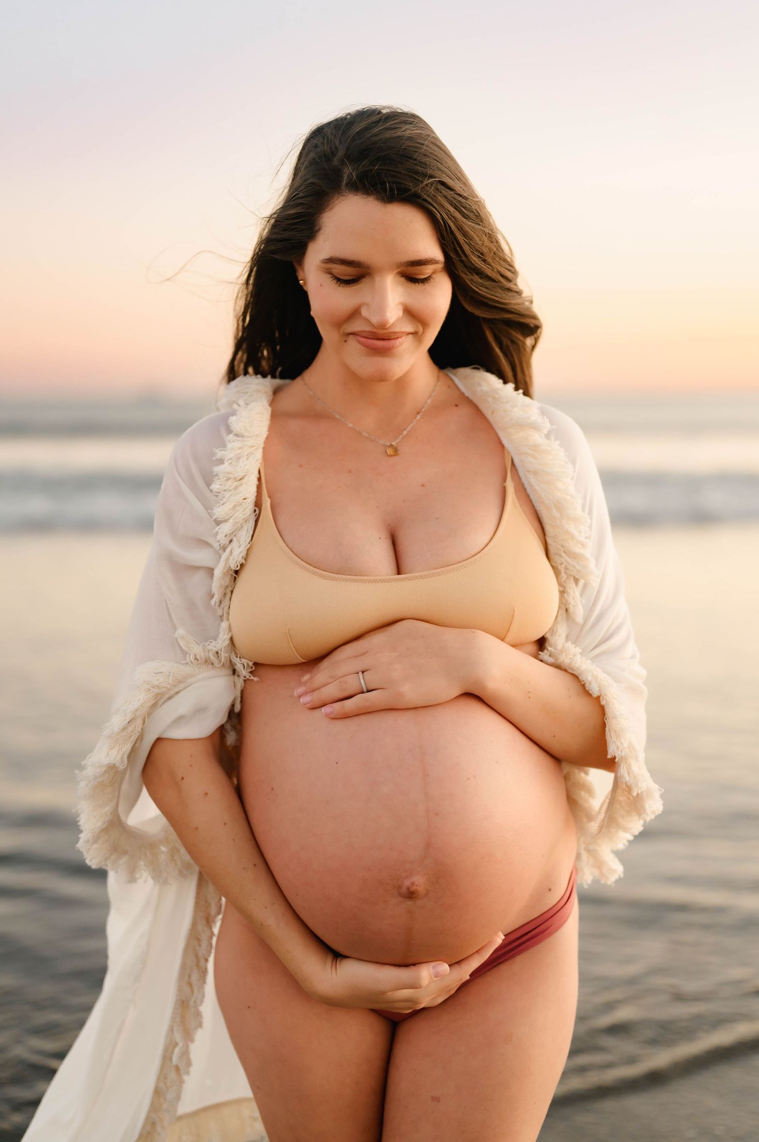 Ventura Beach sunset maternity photoshoot by Ojai maternity photographer of woman in bikini holding bare belly
