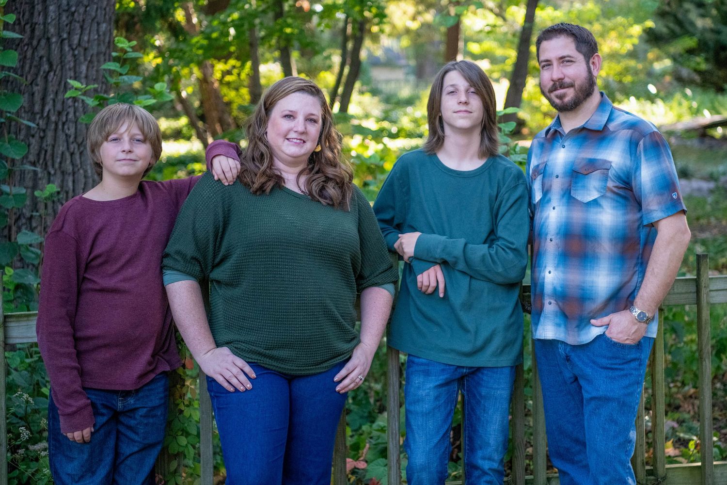 A series of casual outdoor family portraits taken in a lush green forest setting during golden hour lighting.