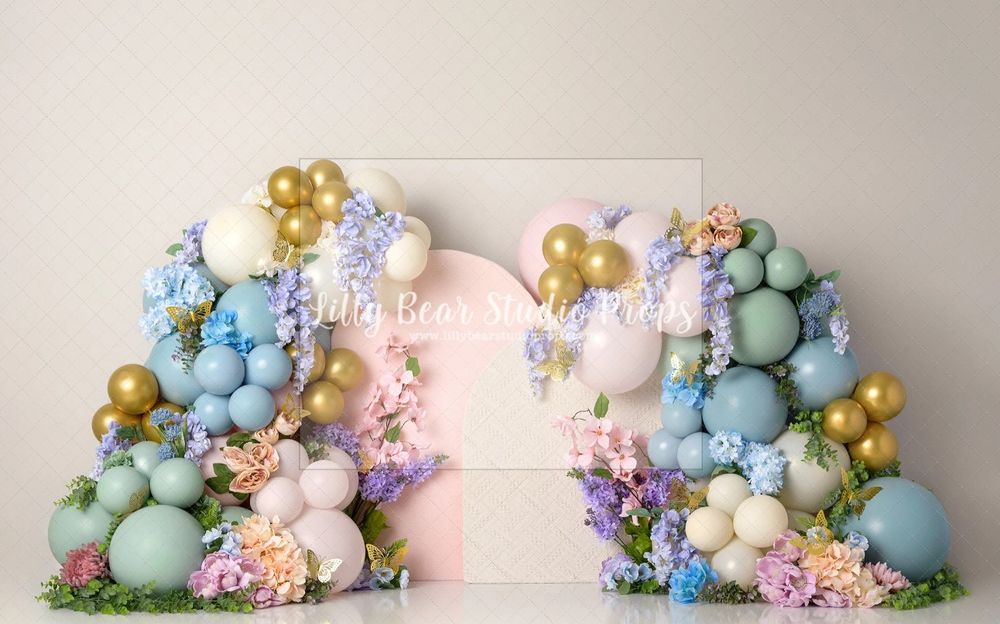 Pastel balloon arch with gold accents and floral decorations in soft pink, blue and mint green colors. Cake smash photography