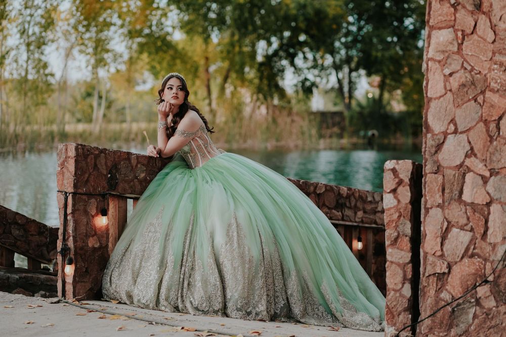 Stunning mint green quinceañera dress photographed by rustic waterfront setting.