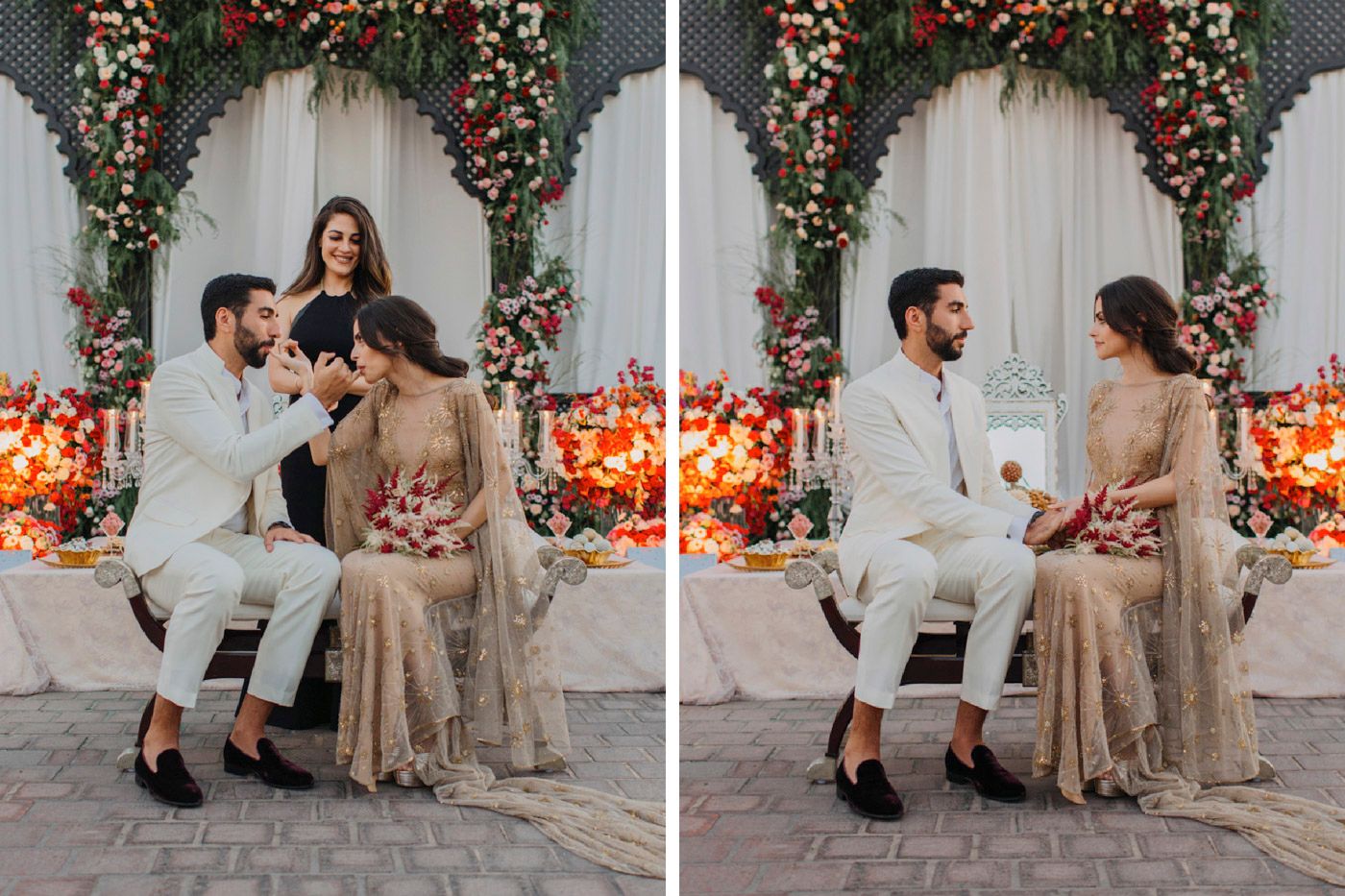 Elegant couple in traditional Indian wedding attire seated under floral arch with romantic lighting and decorations.