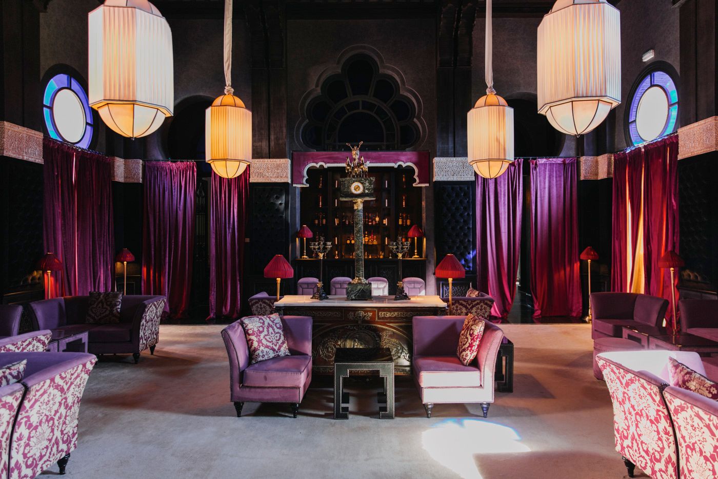 Sophisticated lounge space with oriental lanterns and plush purple seating arrangements.
