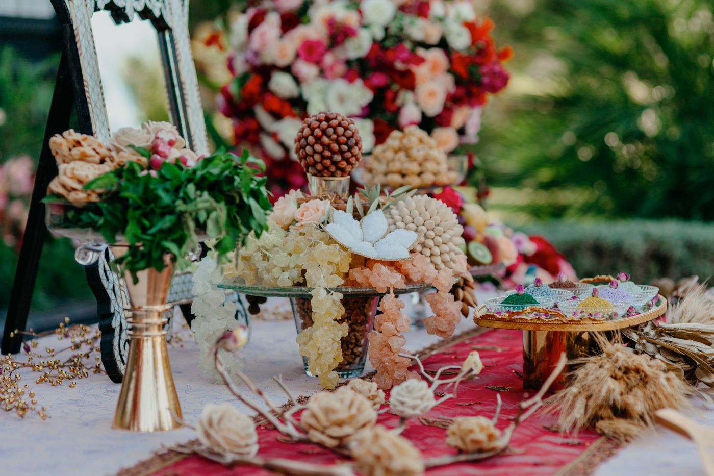 Elegant table setting with floral arrangements and decorative elements at an outdoor event.