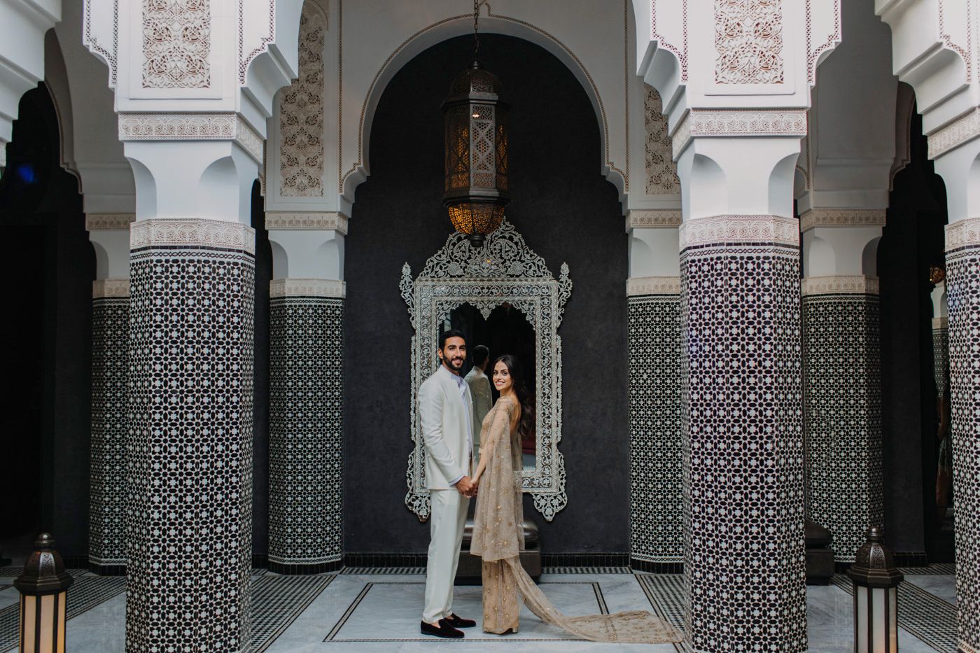 Romantic couple portrait in traditional Middle Eastern architecture with geometric patterns and arches.