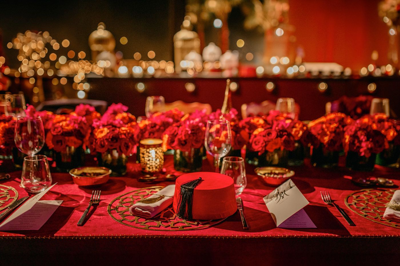 Elegant table setting with red roses and glowing candles at a formal dinner event.
