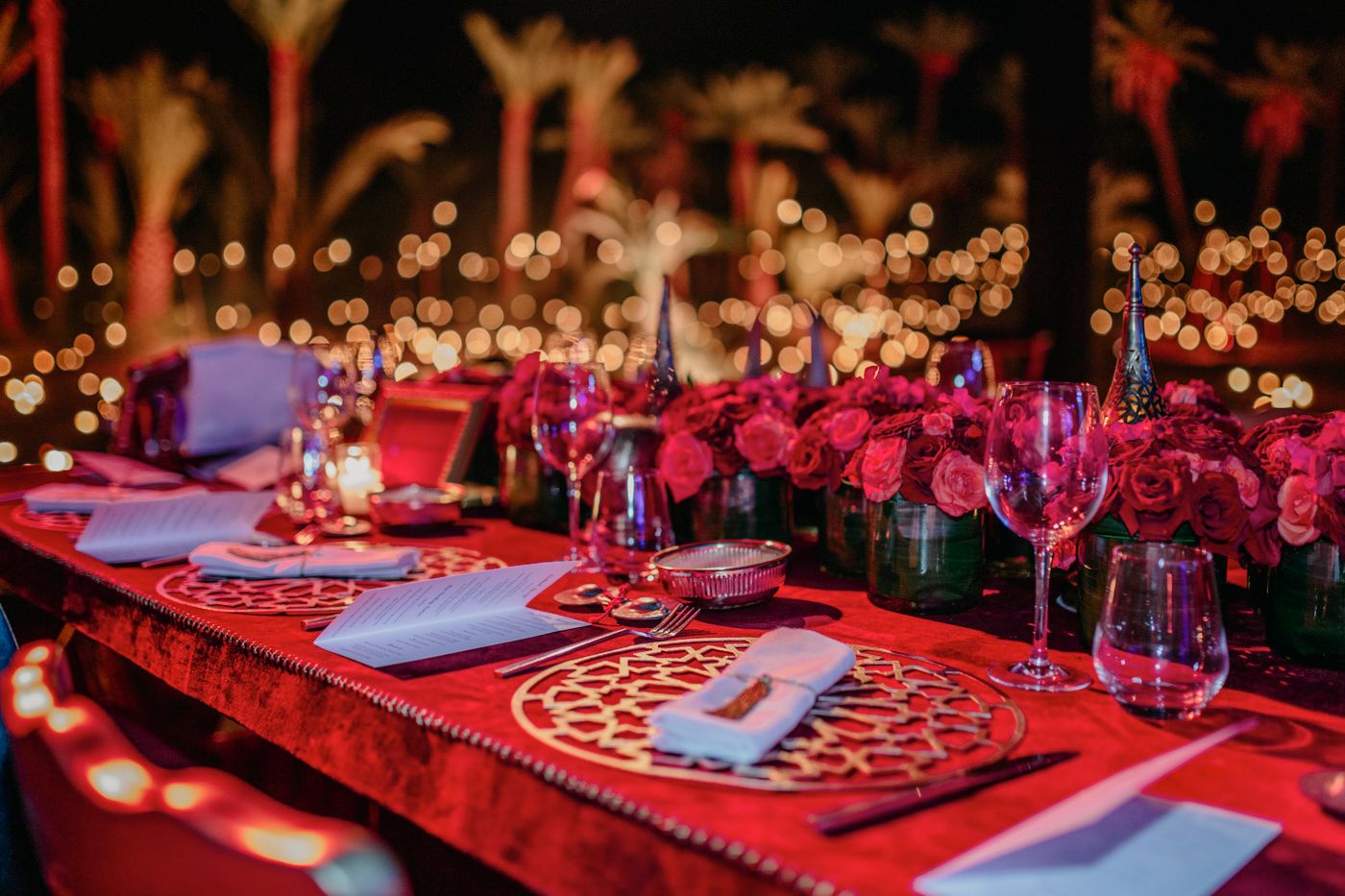 Luxurious red and white table decor with pink floral centerpieces and crystal glassware.