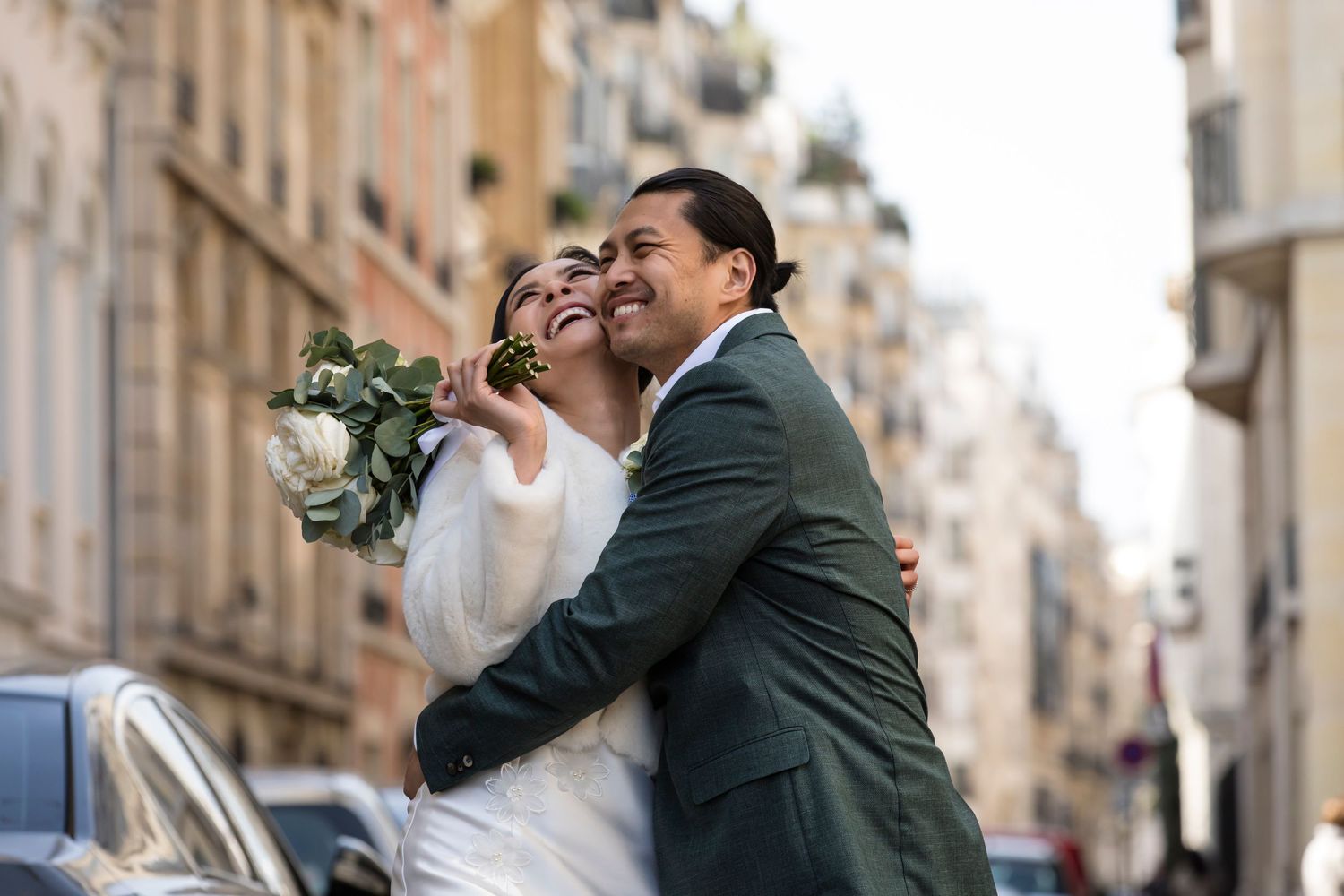 Beautiful couple bride and groom smiling with great joy while captured by Julien LB Photography in the streets of Paris