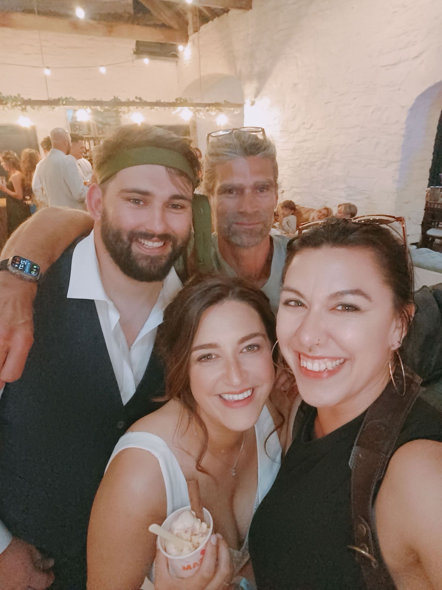 Friends smiling together at a formal celebration or party.