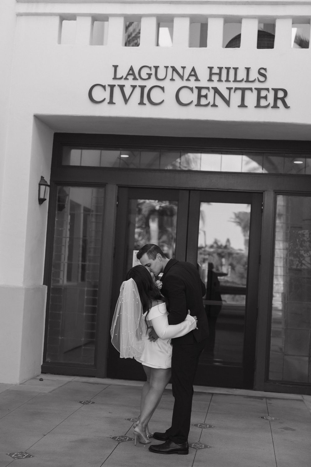 A couple stands outside the entrance of the Laguna Hills Civic Center building.