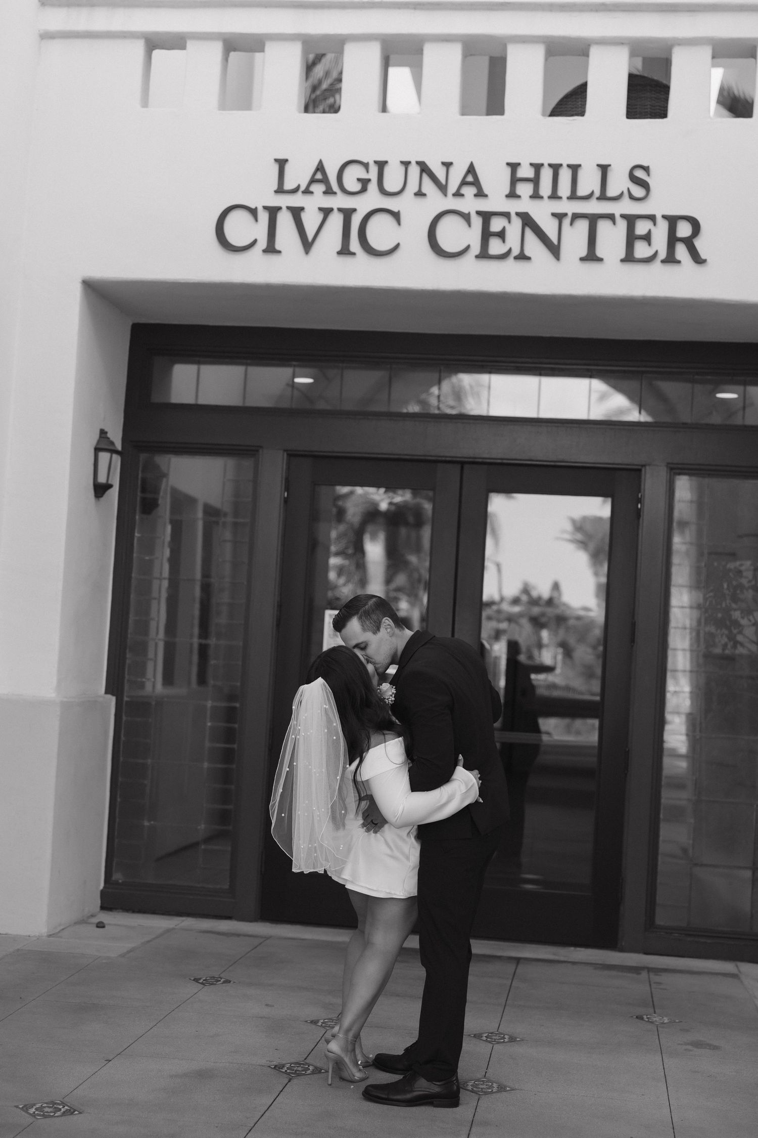 A couple stands outside the entrance of the Laguna Hills Civic Center building.