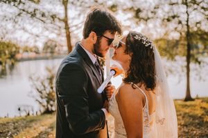 A couple shares a romantic moment at sunset in an outdoor autumn setting, surrounded by golden light and trees.