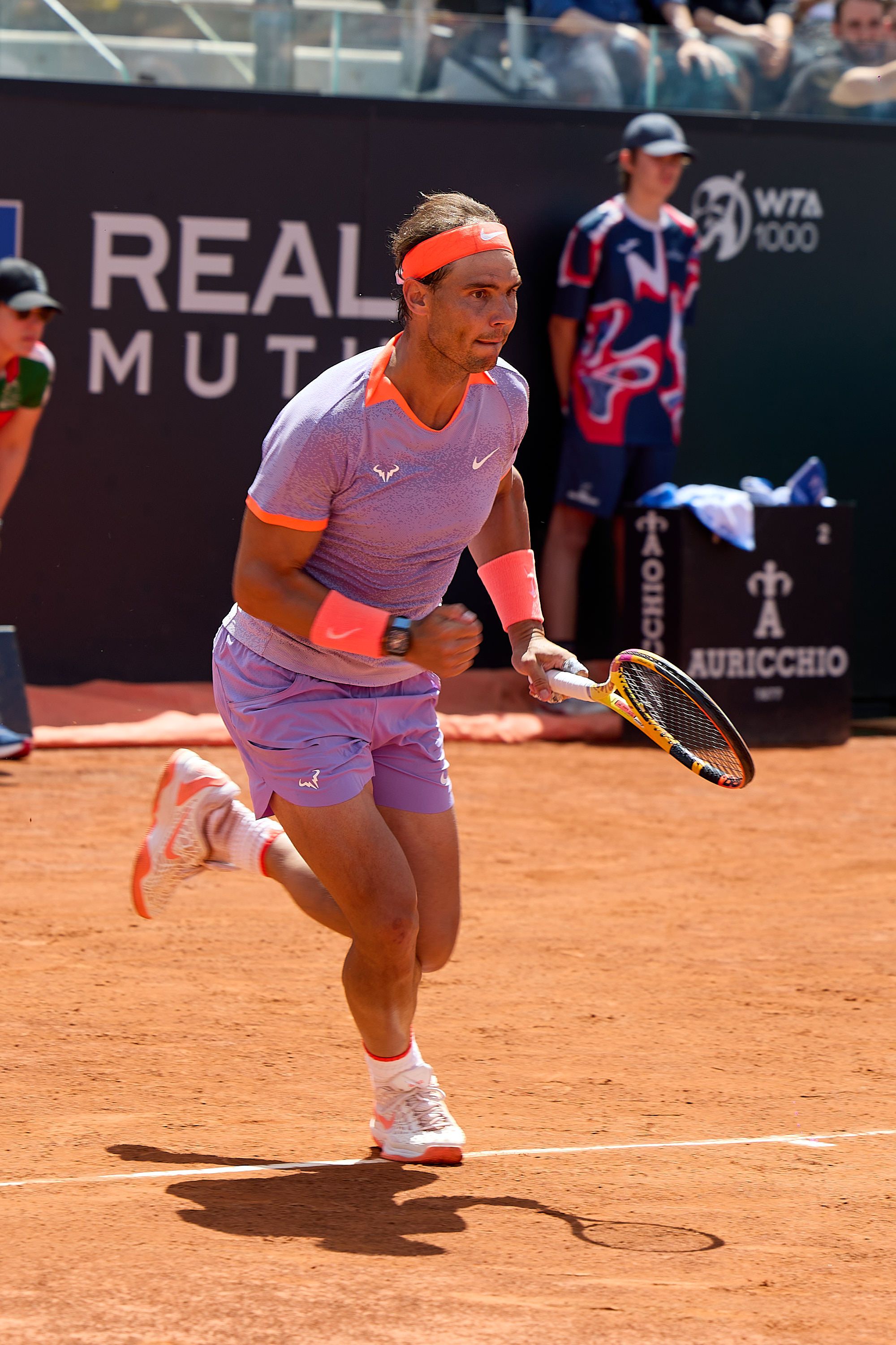 Tennis player in motion on clay court during Reale Mutua tournament.