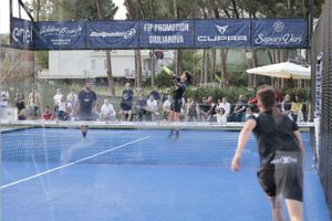Action shot of padel tennis match with spectators in background.