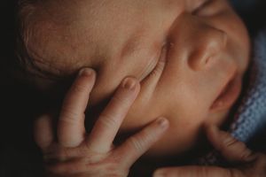 Extreme close-up of a newborn's delicate features and tiny hand.