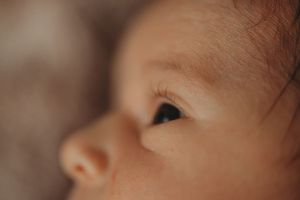 Extreme close up of a baby's eye and nose in soft natural lighting.