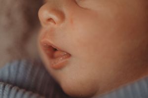 Macro shot of a baby's lips and nose in warm tones.