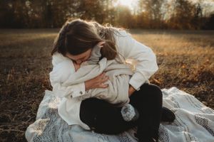 An intimate moment on a blanket in a golden autumn field during sunset.