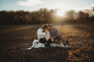 A tender family moment shared on a blanket in a sunlit autumn field.