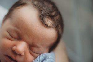 Peaceful sleeping newborn baby in soft focus close-up portrait.