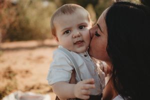 Intimate moment between parent and baby during outdoor portrait session.