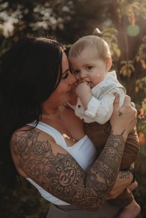 An intimate portrait showcasing detailed arm tattoos while sharing a tender moment.