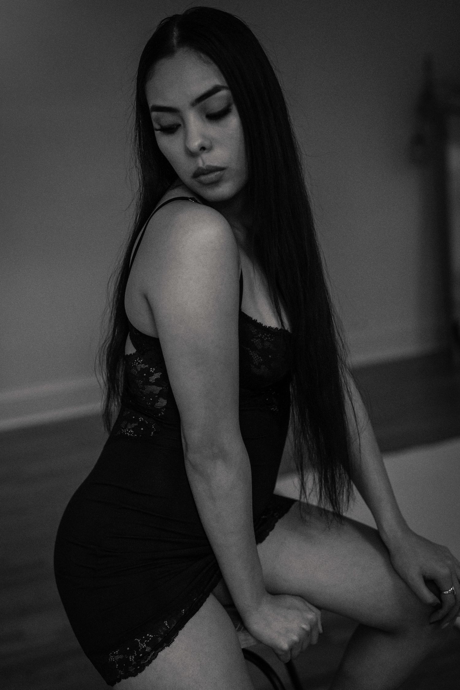 Moody black and white portrait in lace lingerie with long dark hair.